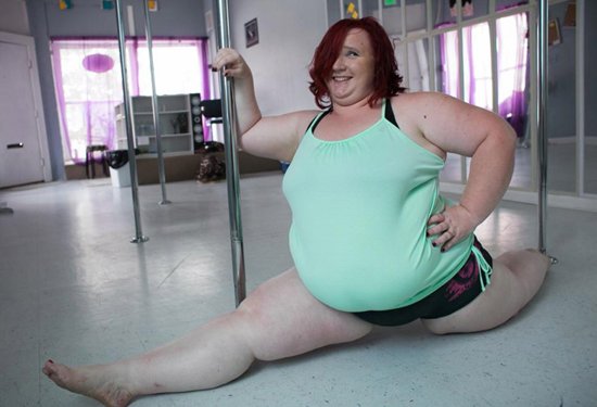 толстая девушка сидит на шпагате в зале