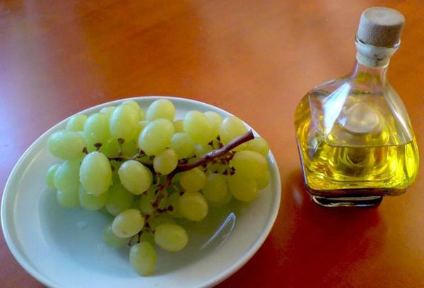 белый виноград на тарелке и бутылка с уксусом