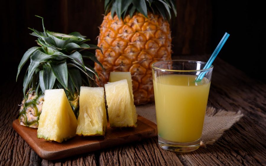 Кусочки ананаса и сок ананасовый в стакане с трубочкой