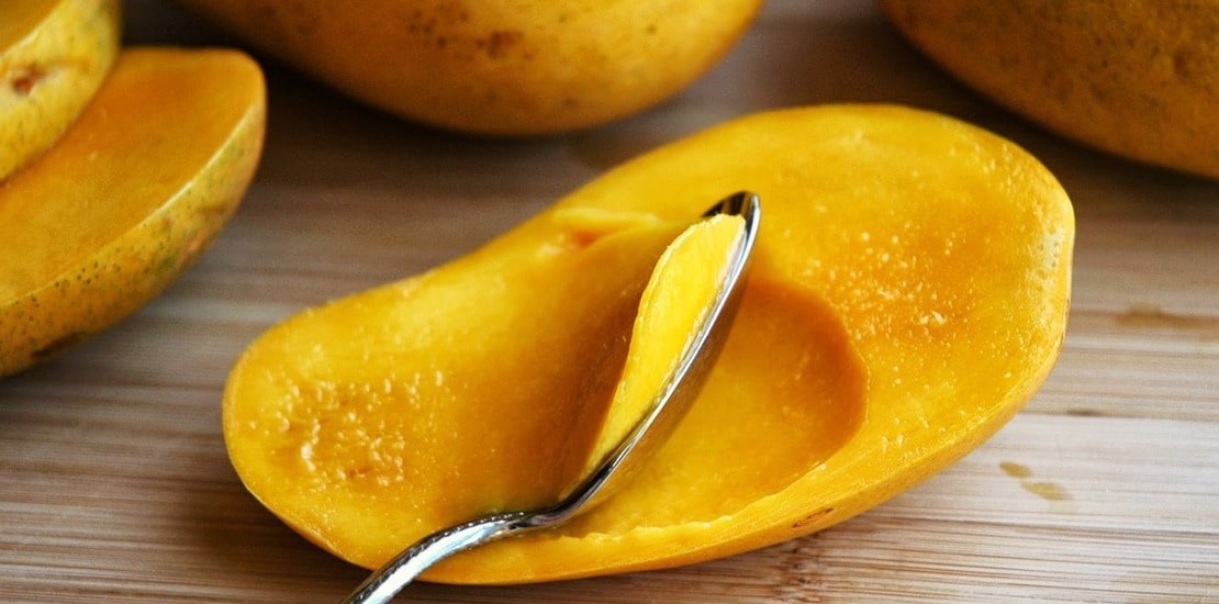 половинка манго с ложечкой внутри
