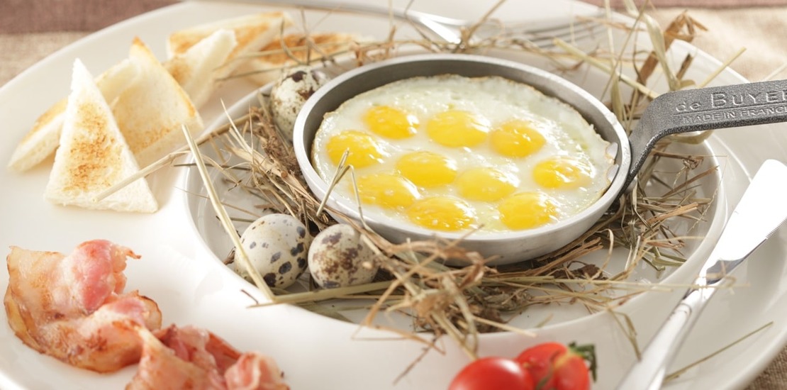 яичница из перепелиных яиц в маленькой сковороде на столе